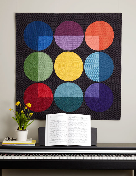 black quilt with circles in nine colors