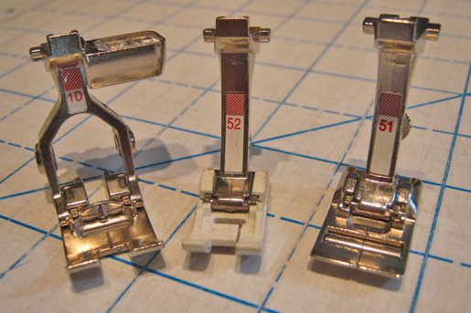 three sewing machine presser feet