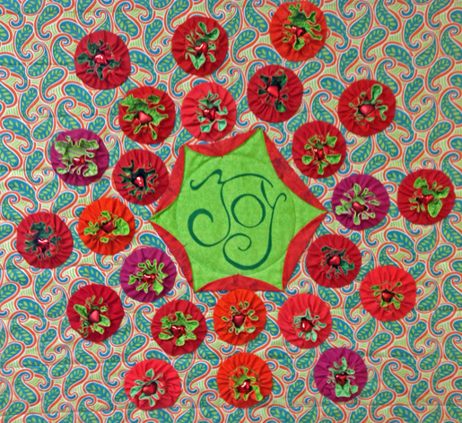 Yo-yo's stitched in place, drawn up with little red hearts