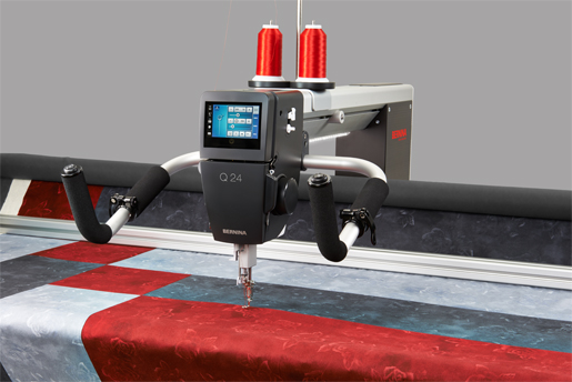 BERNINA Q24 close up with red and grey quilt---handles up