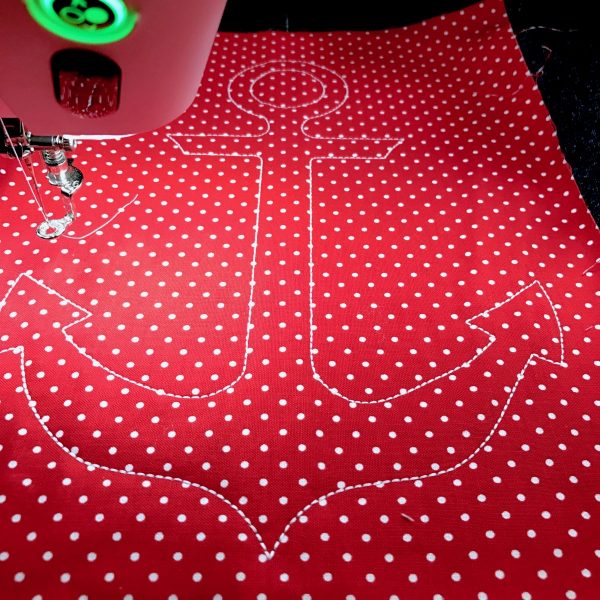 Remove the paper backing from the back of the applique fabric. Place the fabric, right side up, over the placement line. Sew Stitch Sequence 2 to create the cutting line.