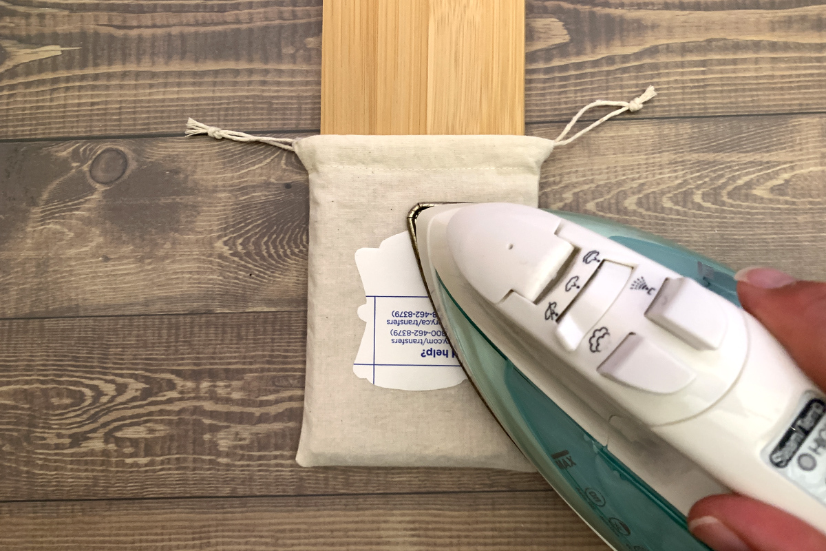 Tooth Fairy Drawstring Pouch Pattern: Ironing the transfer paper decal onto the finished bag using a wooden cutting board instead of an ironing board.