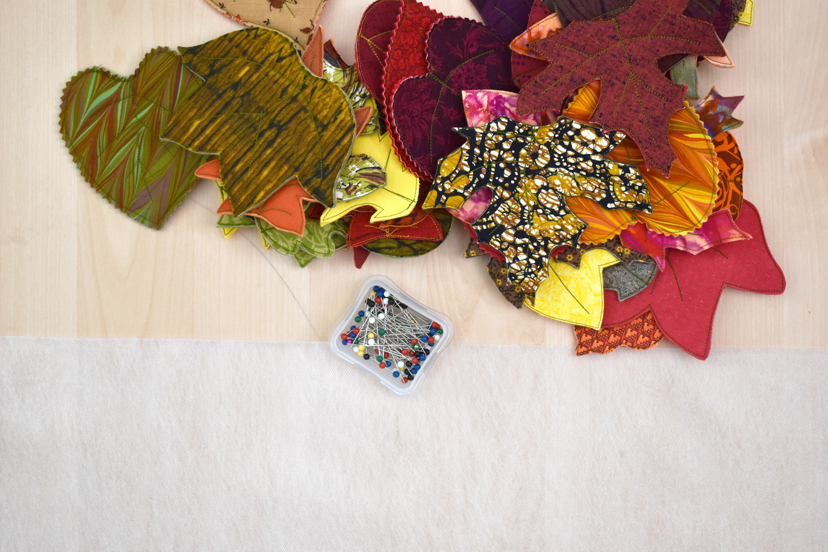 You will need 16-20 leaves without stems to create the trivet, one 14" piece of the 10" wide OESD AquaMesh wash-away stabilizer, sewing pins, and blue painter's tape (optional).
