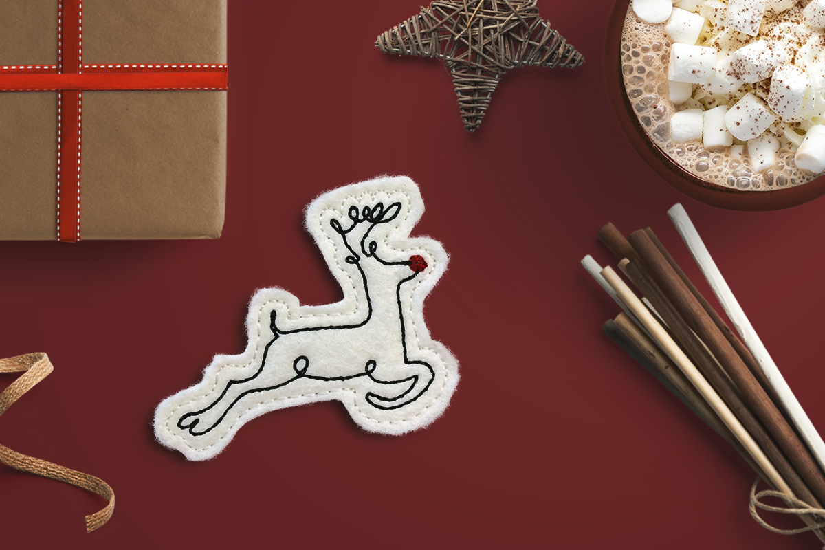 Machine embroidered feltie featuring a stylized reindeer design.