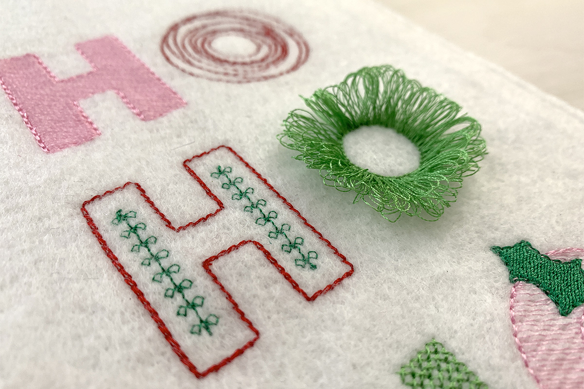 Close up of the 3D fringe turning the letter O into a wreath.