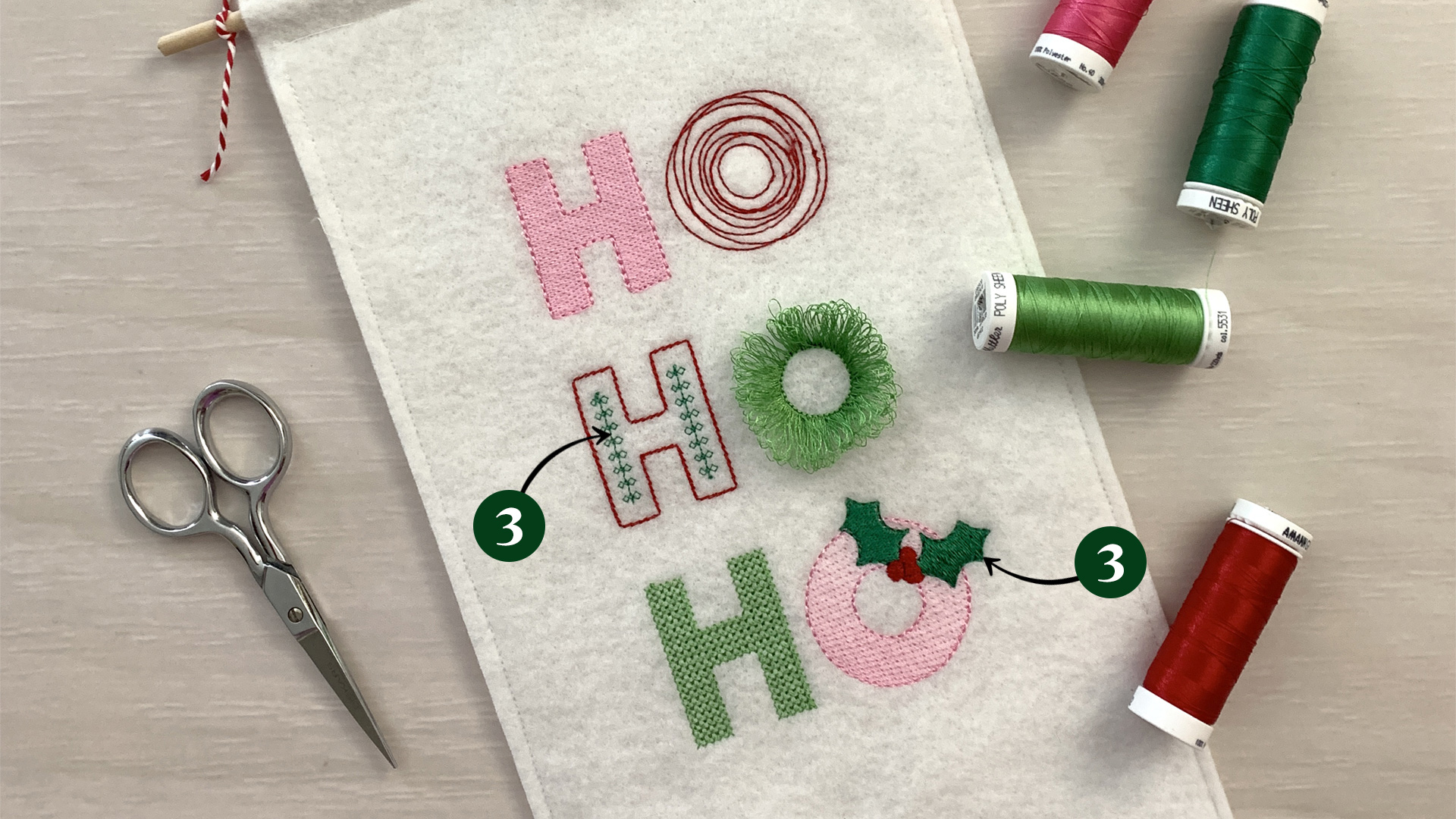 Callout pointing to the inline stitches of the second H and the holly leaves on the last O.