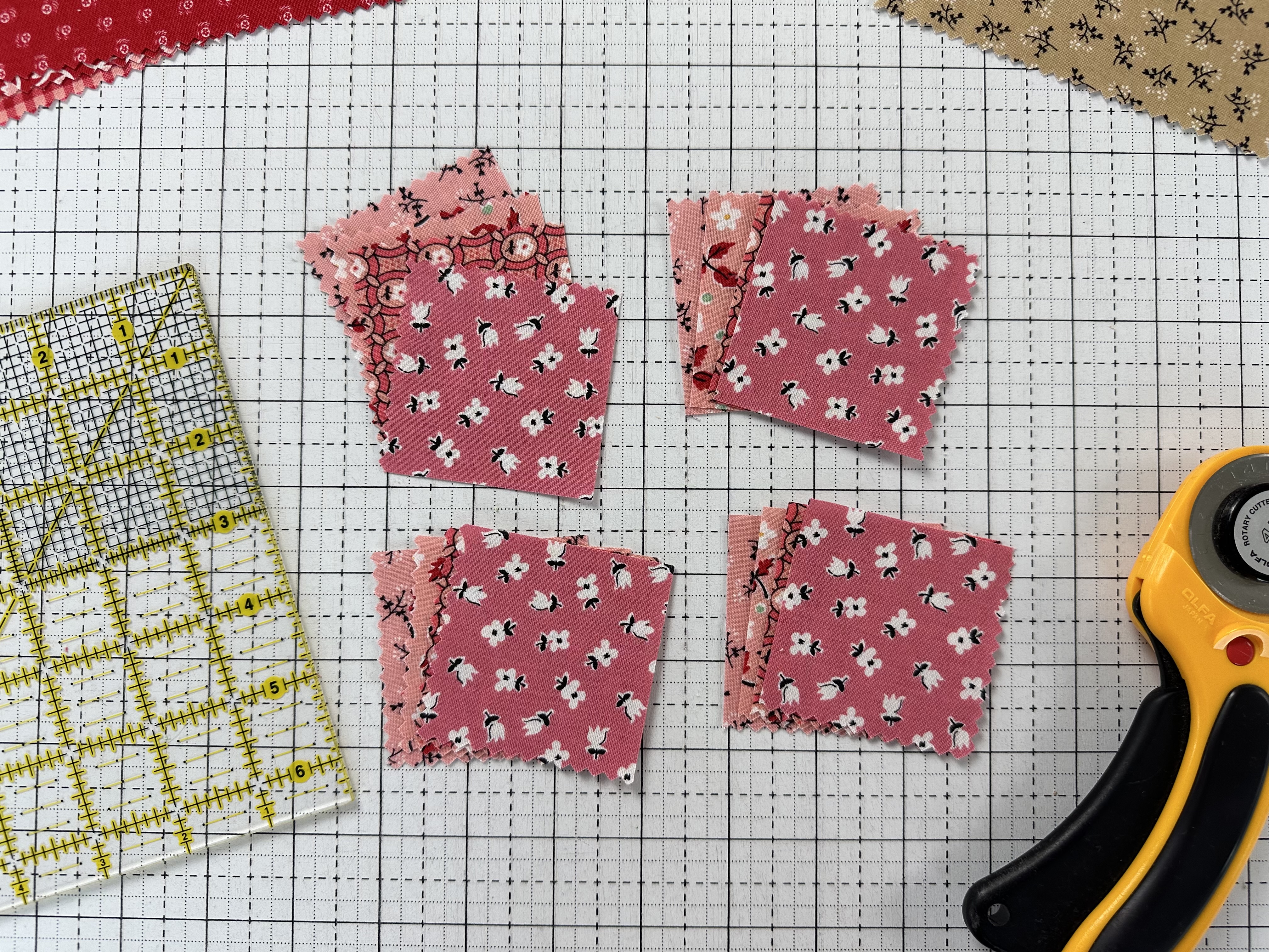 Multiple 2 1/2" squares stacje that were cut from a stack of 5" squares