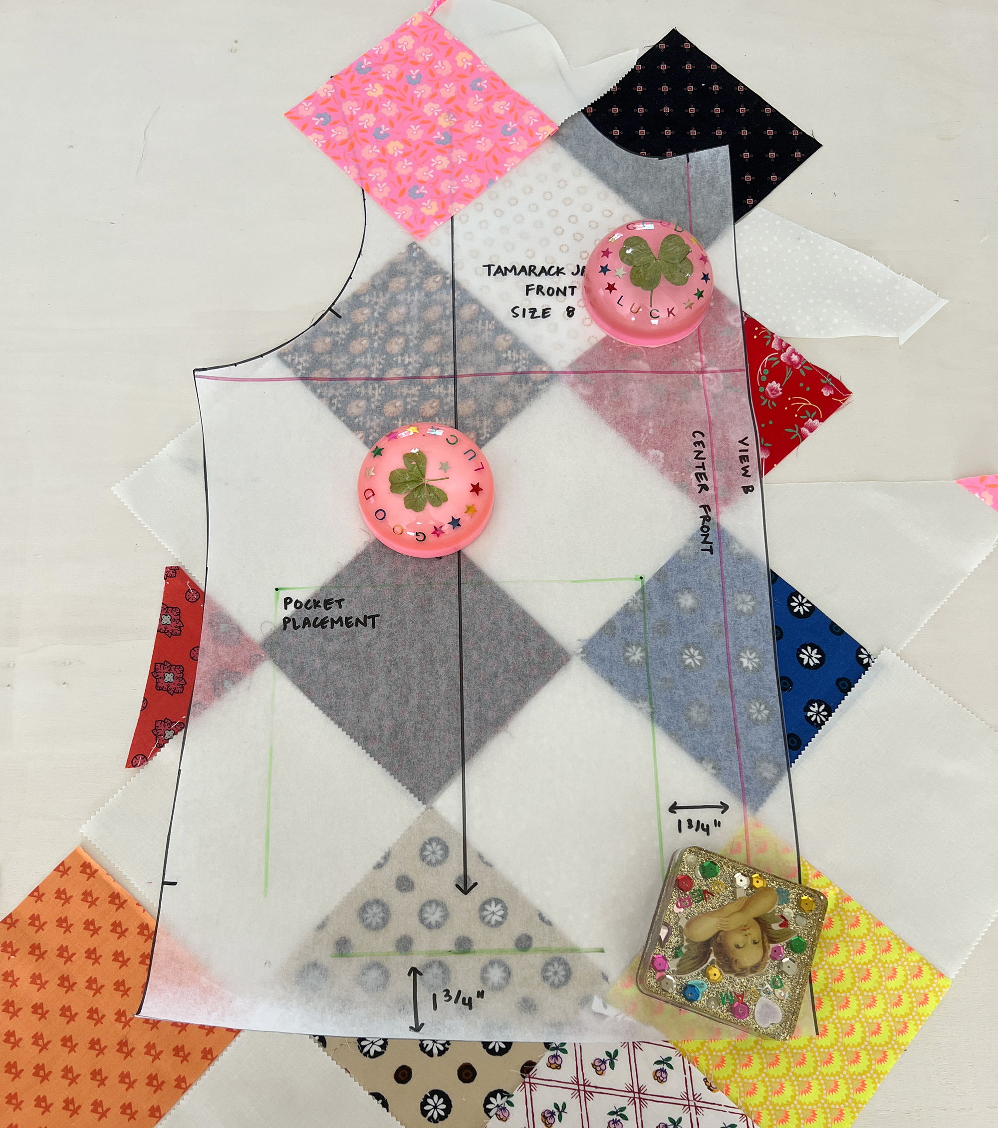 A sewing pattern tissue for a jacket front is laid on top of patchwork fabric.