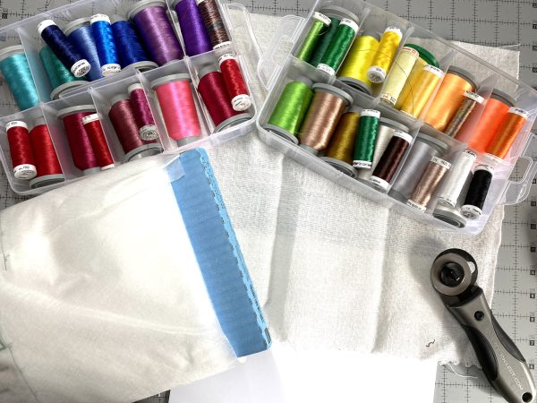 Supplies for decorative stitching, embroidery thread, loosely woven fabric, stabilizer, white cotton