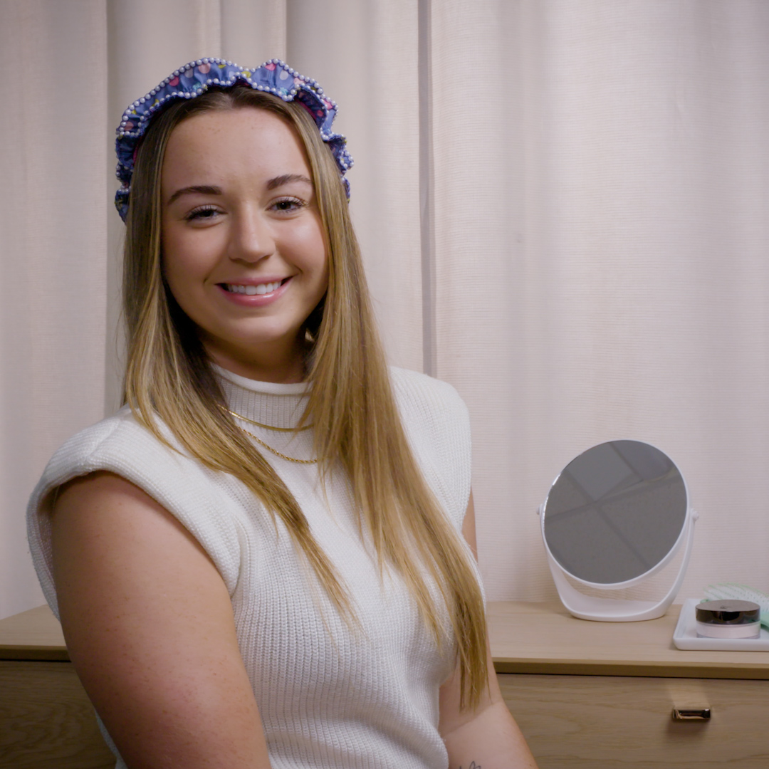 Woman in white sweater, modeling a beaded headband