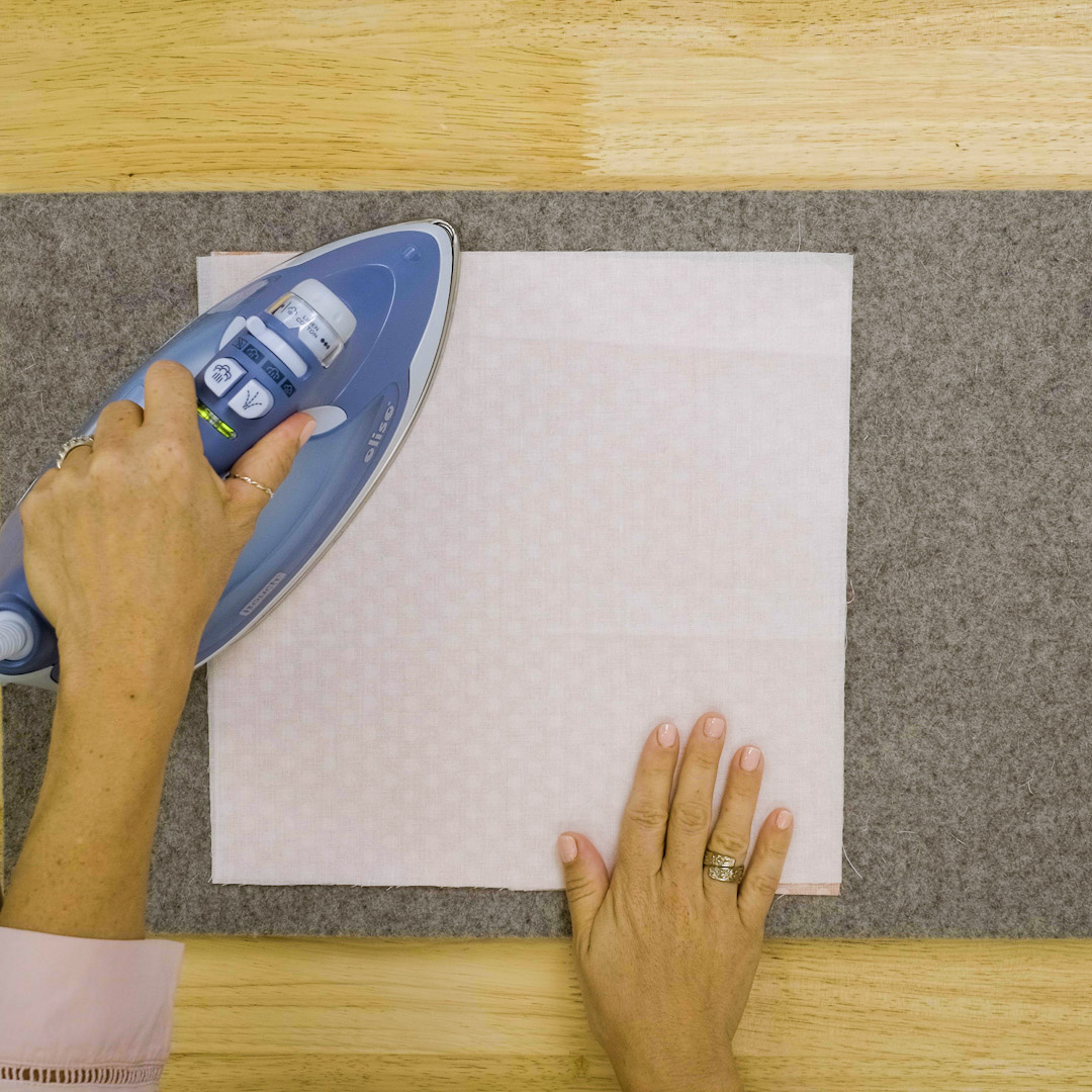 fuse stabilizer; an iron pressing Shape Flex onto a square of fabric