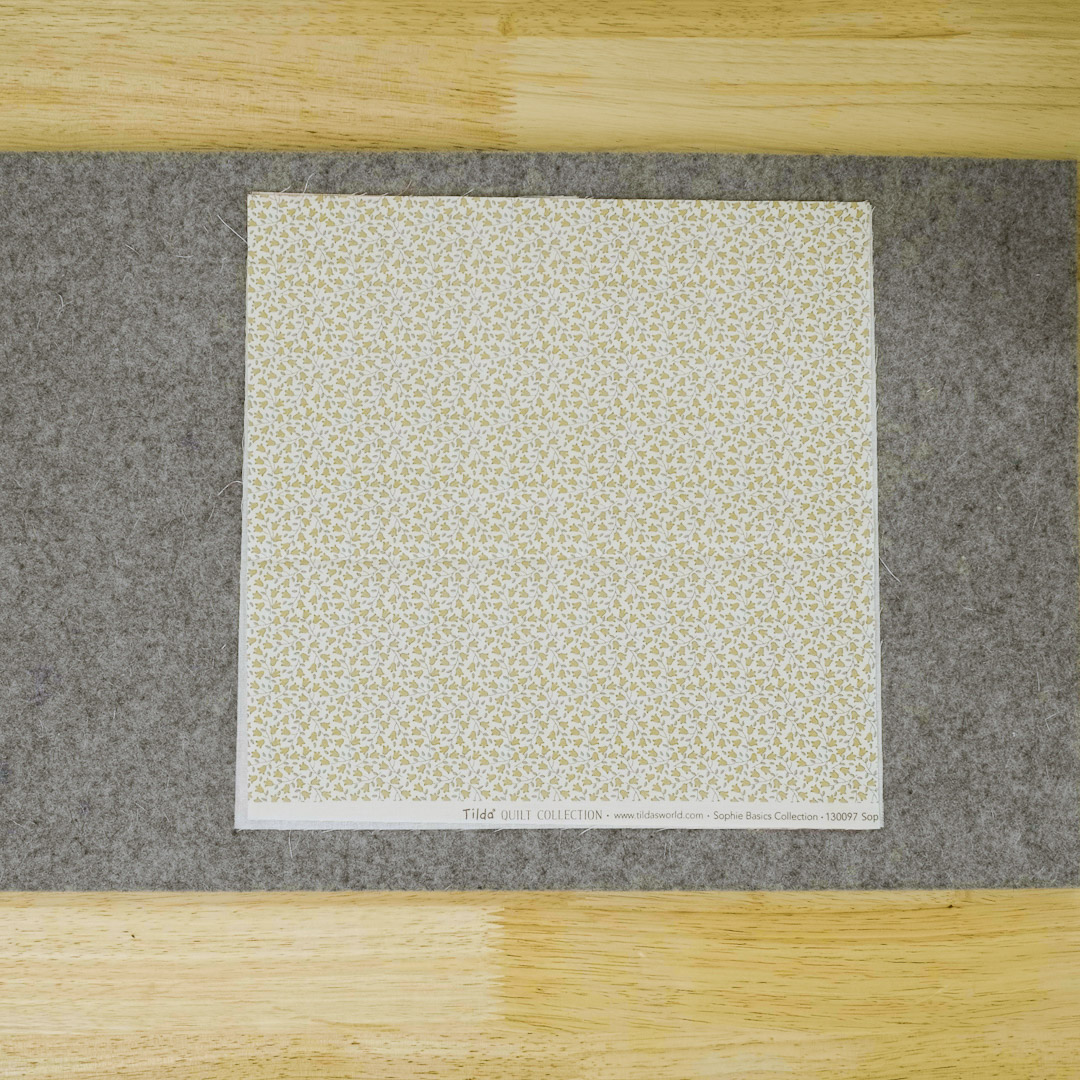 square of fabric showing whimsical yellow flowers on a white background