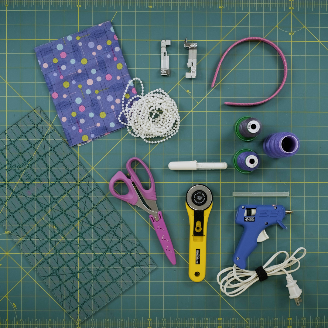 various sewing and serger supplies arranged on a green cutting mat