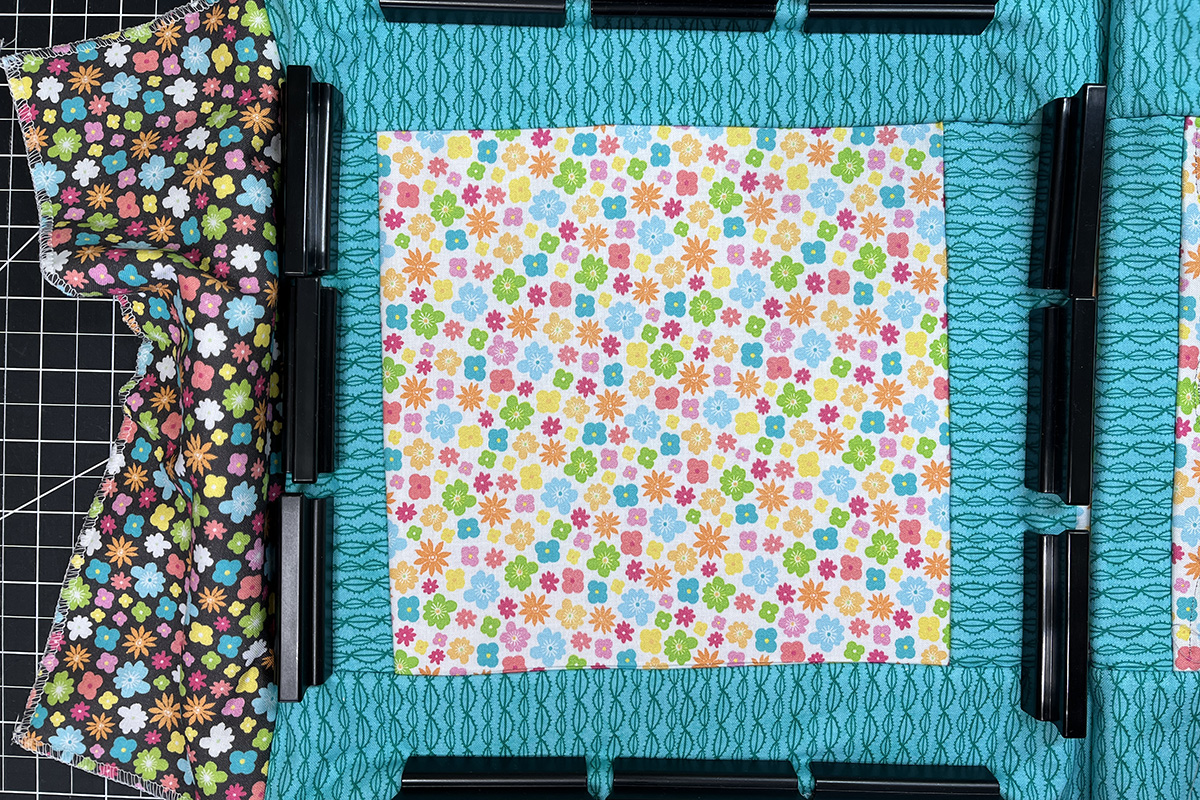 overhead view of multi-colored fabric in a medium clamp embroidery hoop