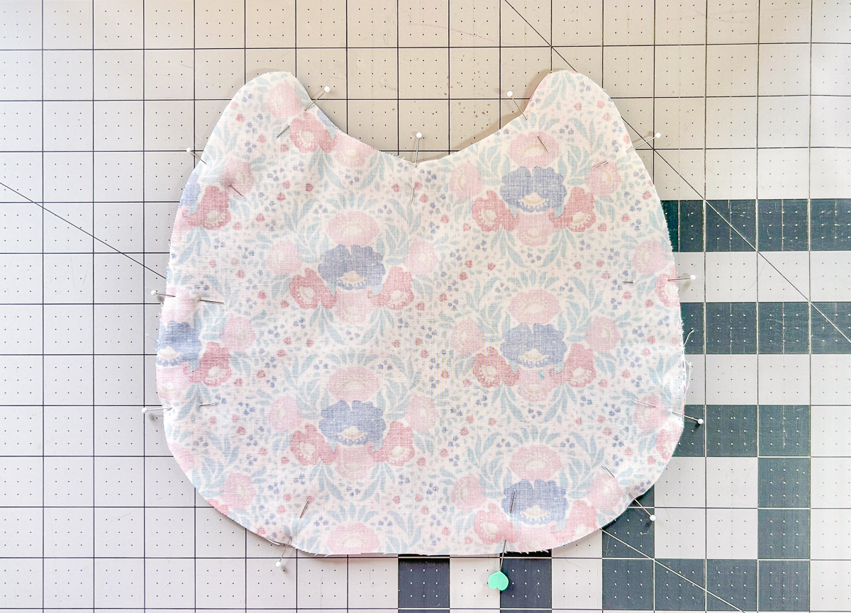 Bib pinned with wrong sides out against cutting mat