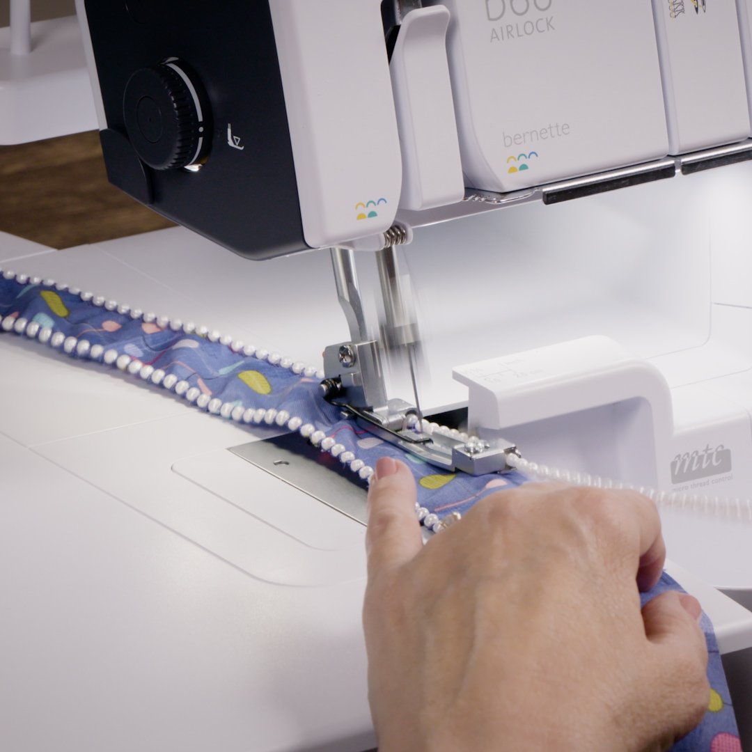 sewing beads onto the other side of a blue fabric strip