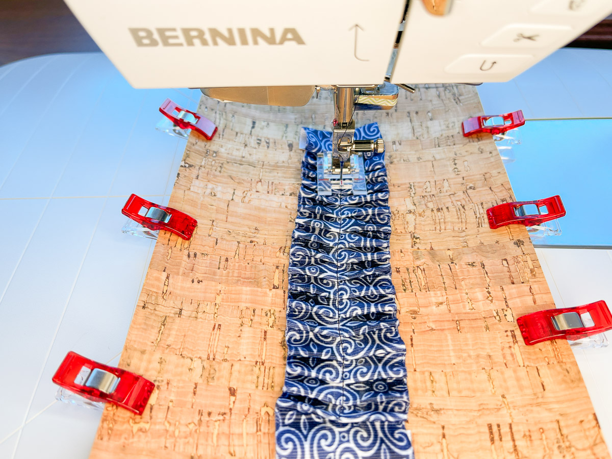 Overhead view of blue ribbon being sewn to cork