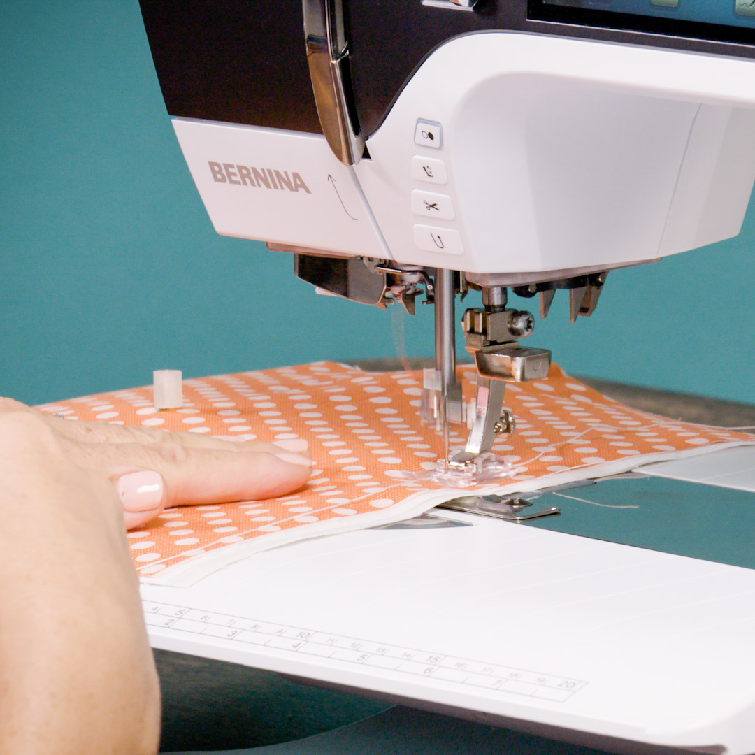 side view of the BERNINA Foot #39C placed correctly over the orange polka dot fabric on the sewing machine