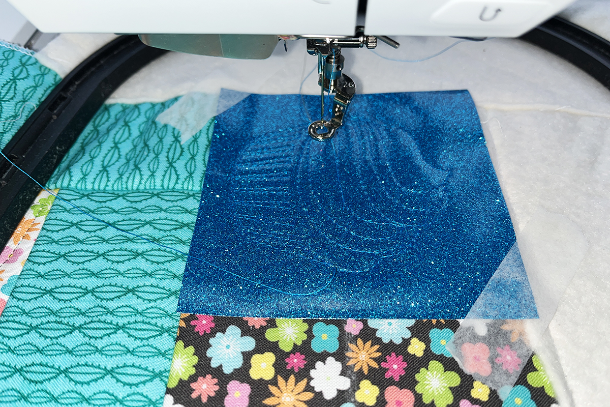 embroidery in progress on blue vinyl