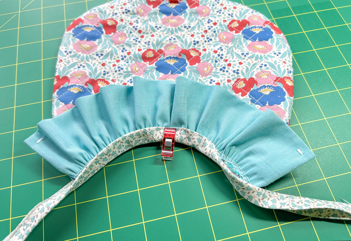 Colorful bib with blue ruffle on green cutting mat