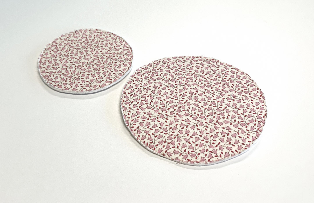 two circular bases in a red floral fabric to fit into the bottom of the fabric bowls