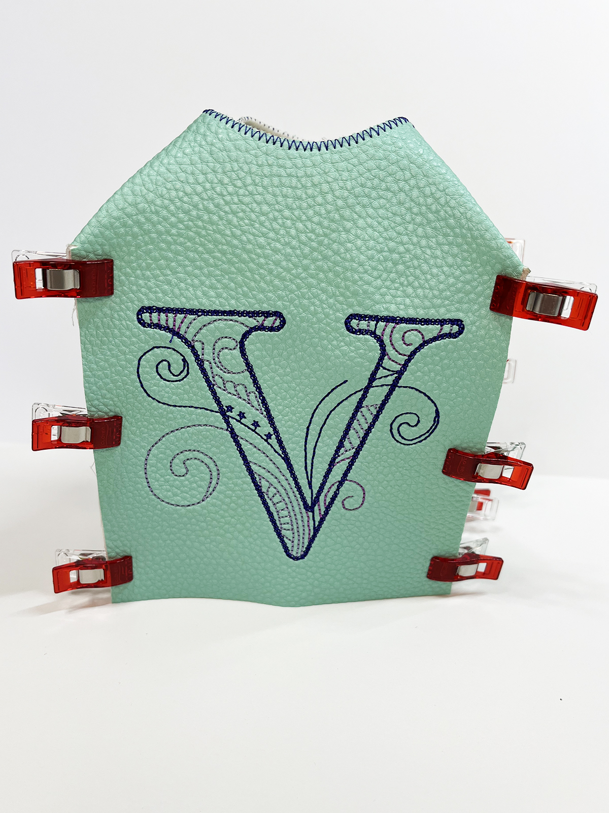Embroidered vinyl 'V' with red clip edges
