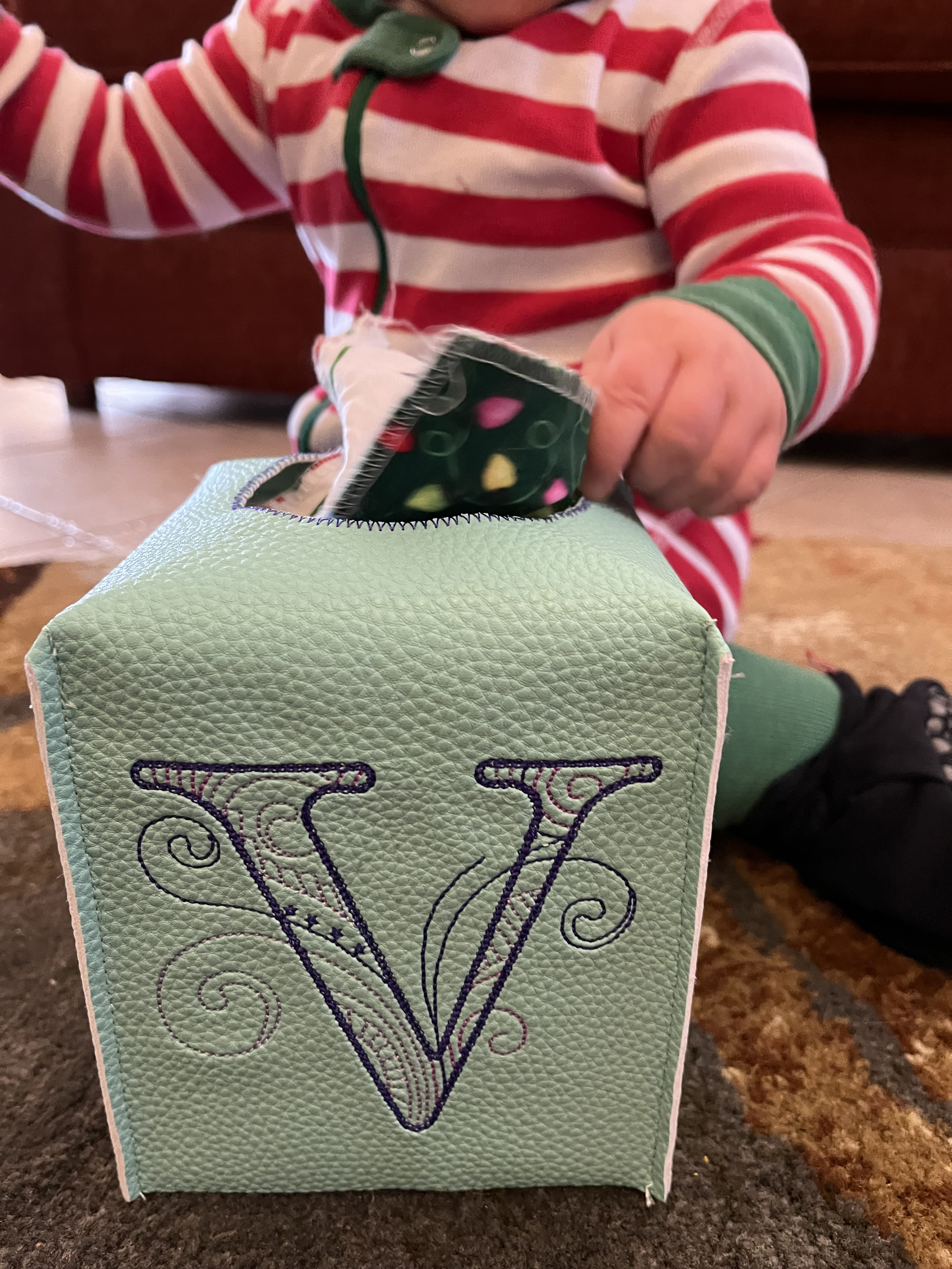The finished sensory toy box with a letter V being played with by a child in red and white pajamas.