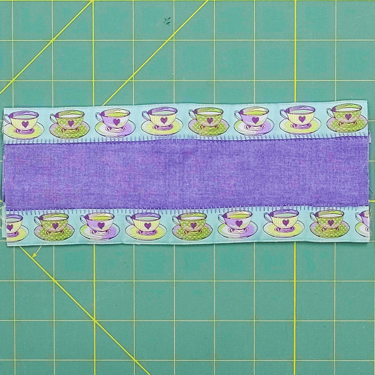 Finished overhead view of the center strip and ribbon borders flat on a cutting board.