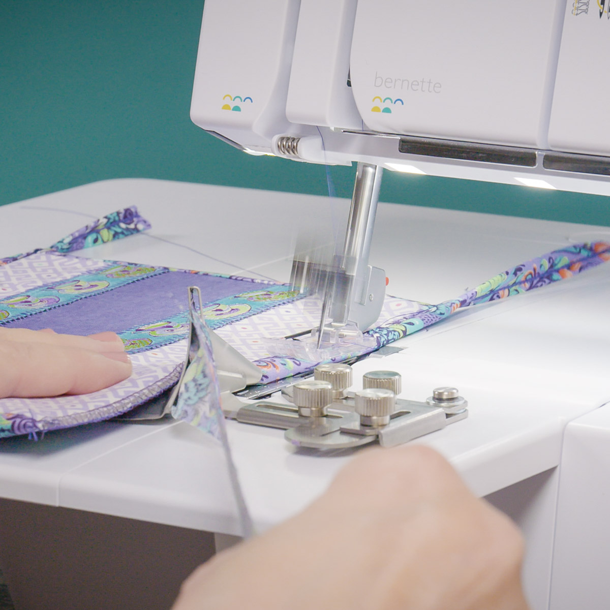 A side view of binding being sewn onto the side of the flatlock snack mat.