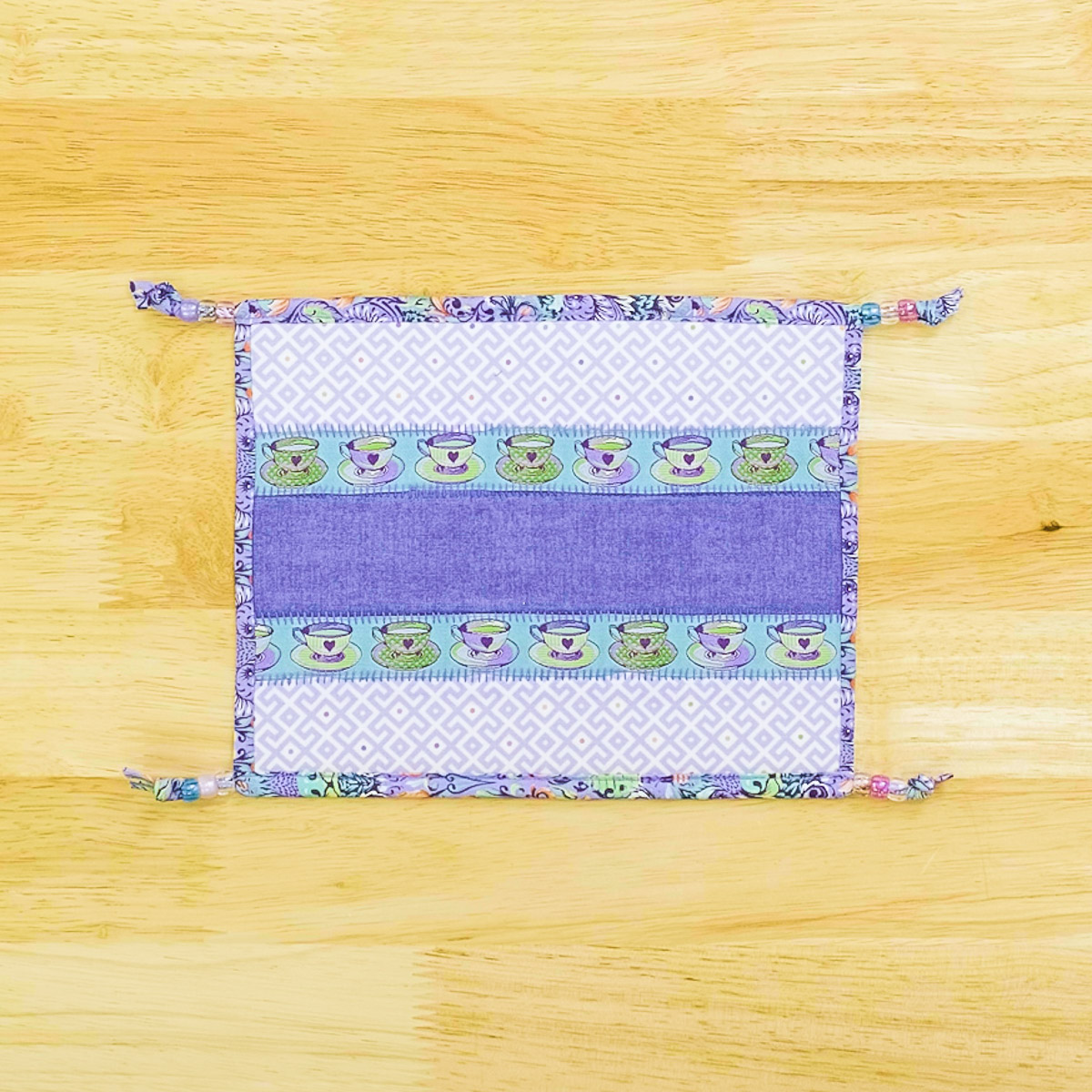 hands ties knots in the binding of the snack mat.