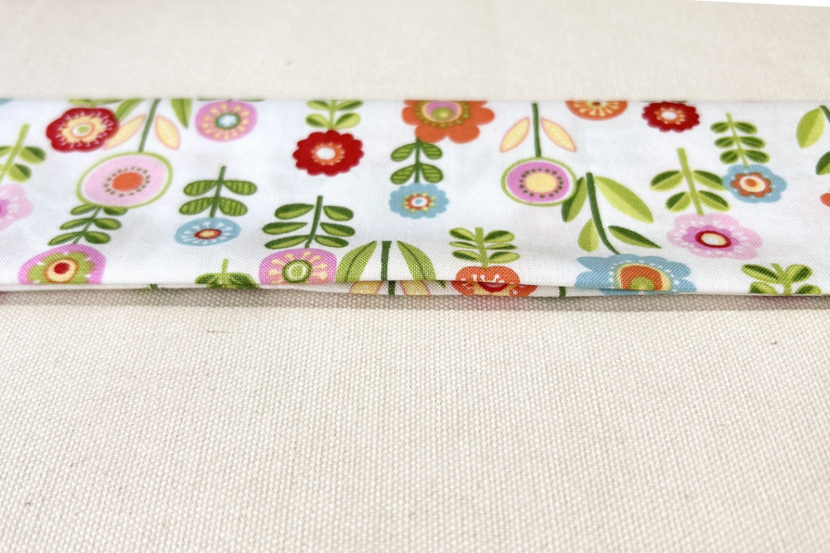 Close-up view of the small opening left in the seam of the flowered fabric.