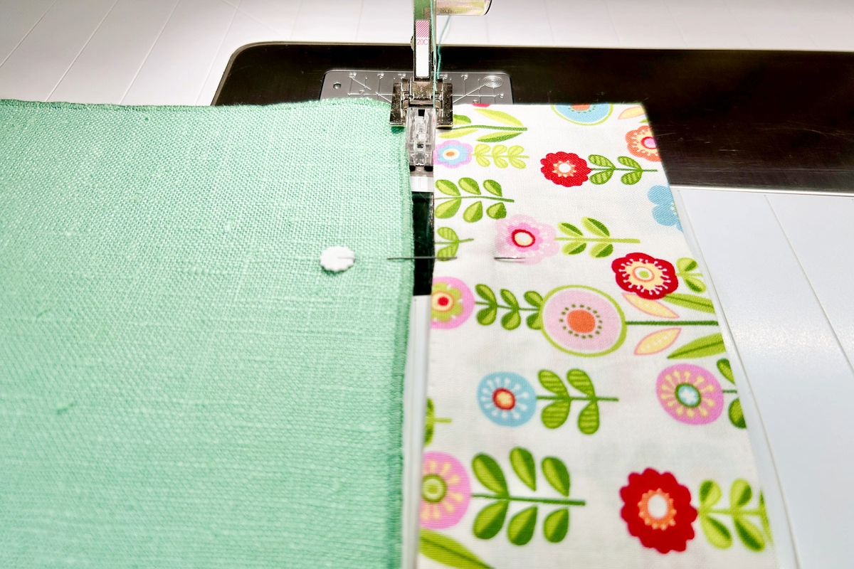Close-up view of the pinned fabric being fed into the Spanish Hemstitch Attachment
