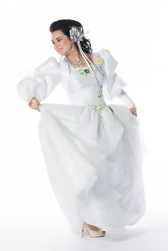Woman wearing Labyrinth-inspired white dress on white background