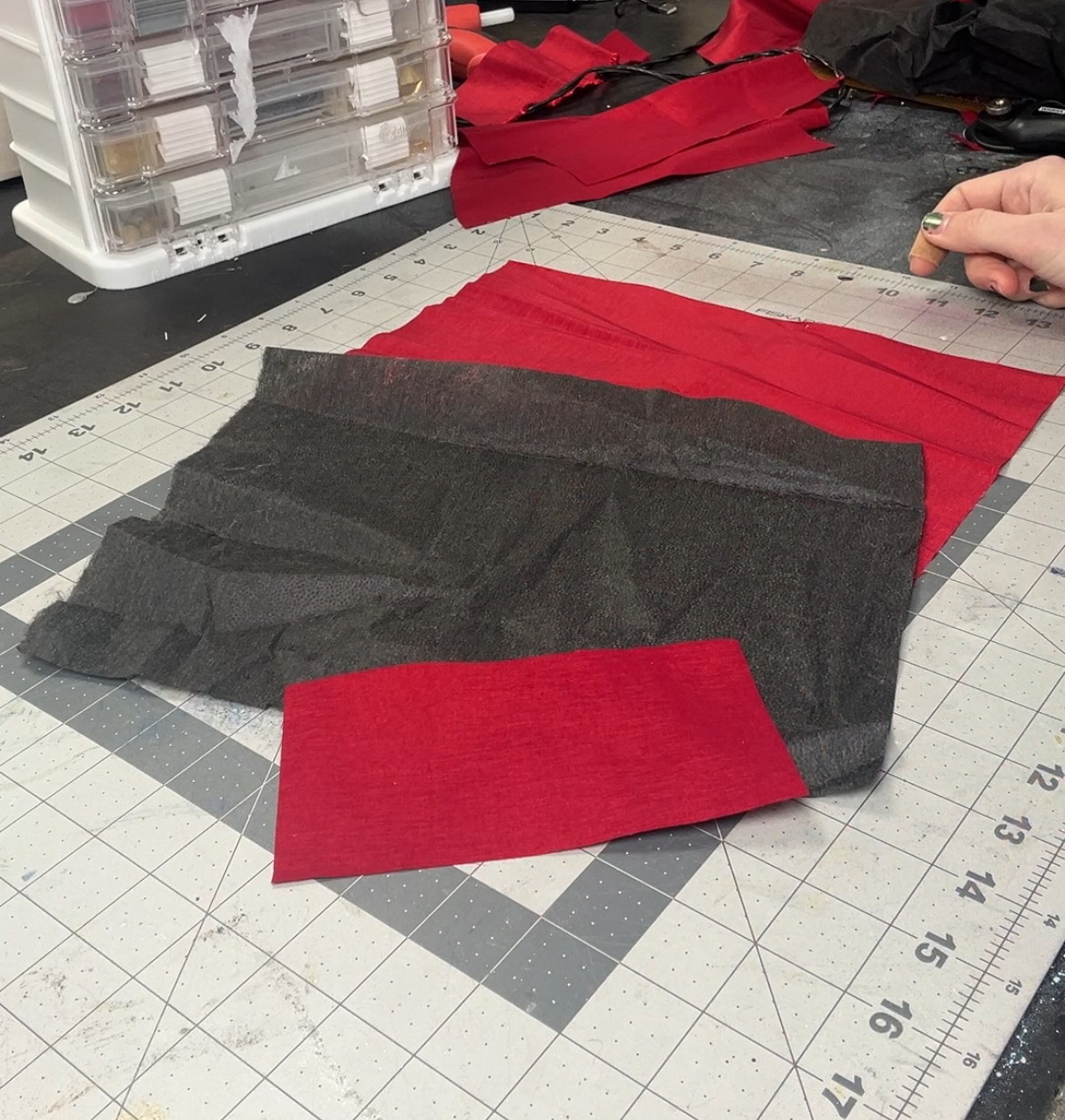 Two pieces of red fabric and one piece of black fusible interfacing