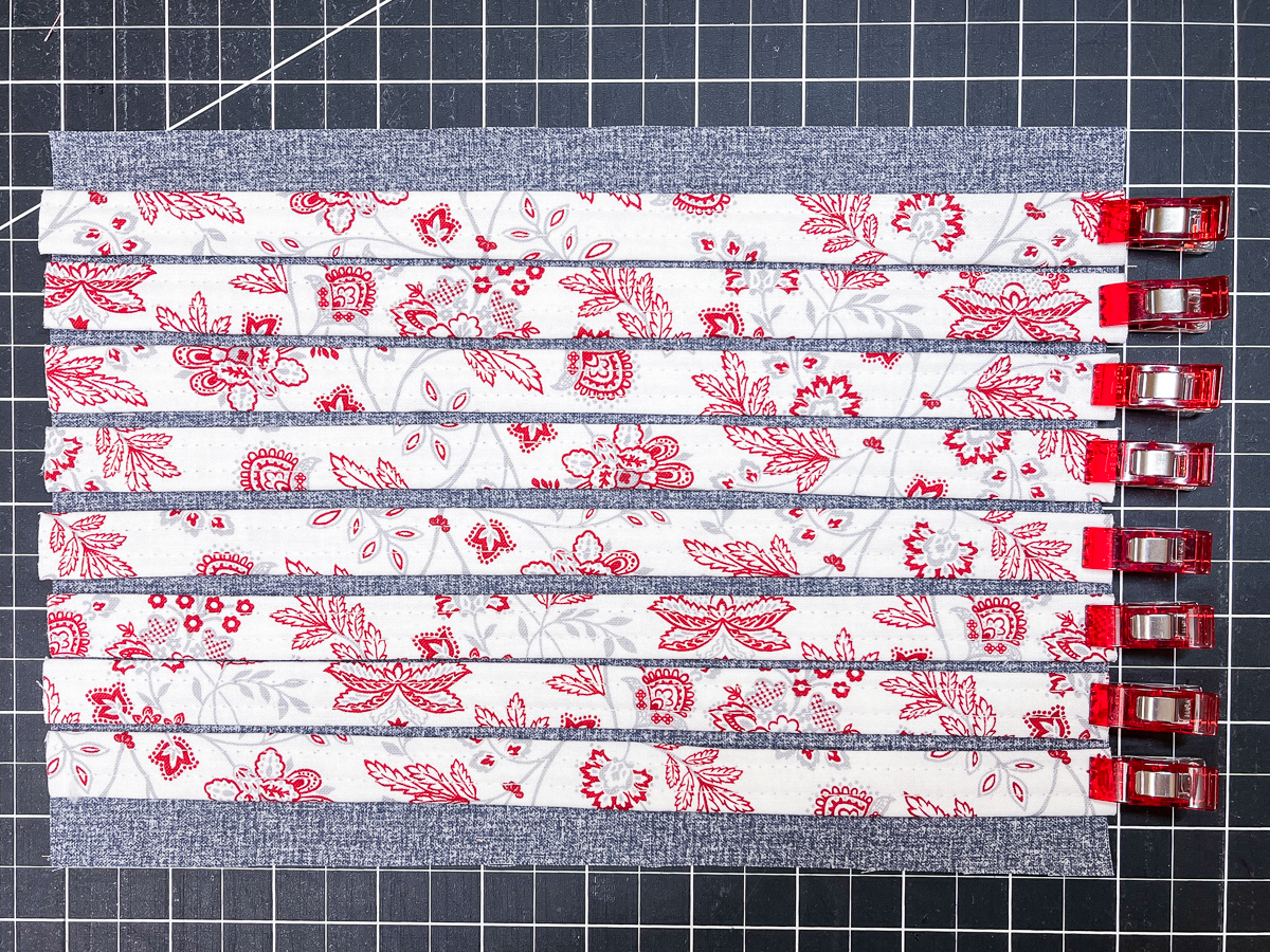 Colorful fabric clipped in place on a cutting board