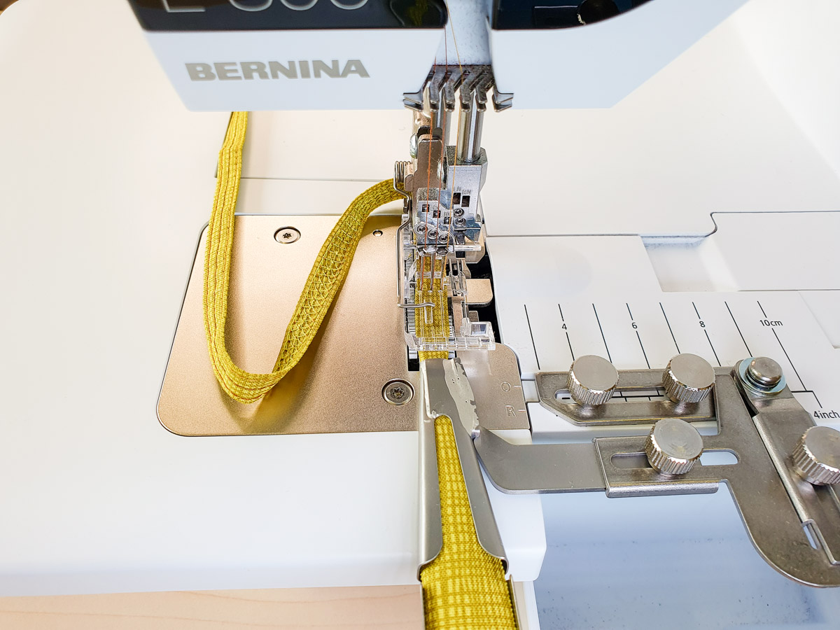 progress photo of yellow fabric being sewn into a belt loop