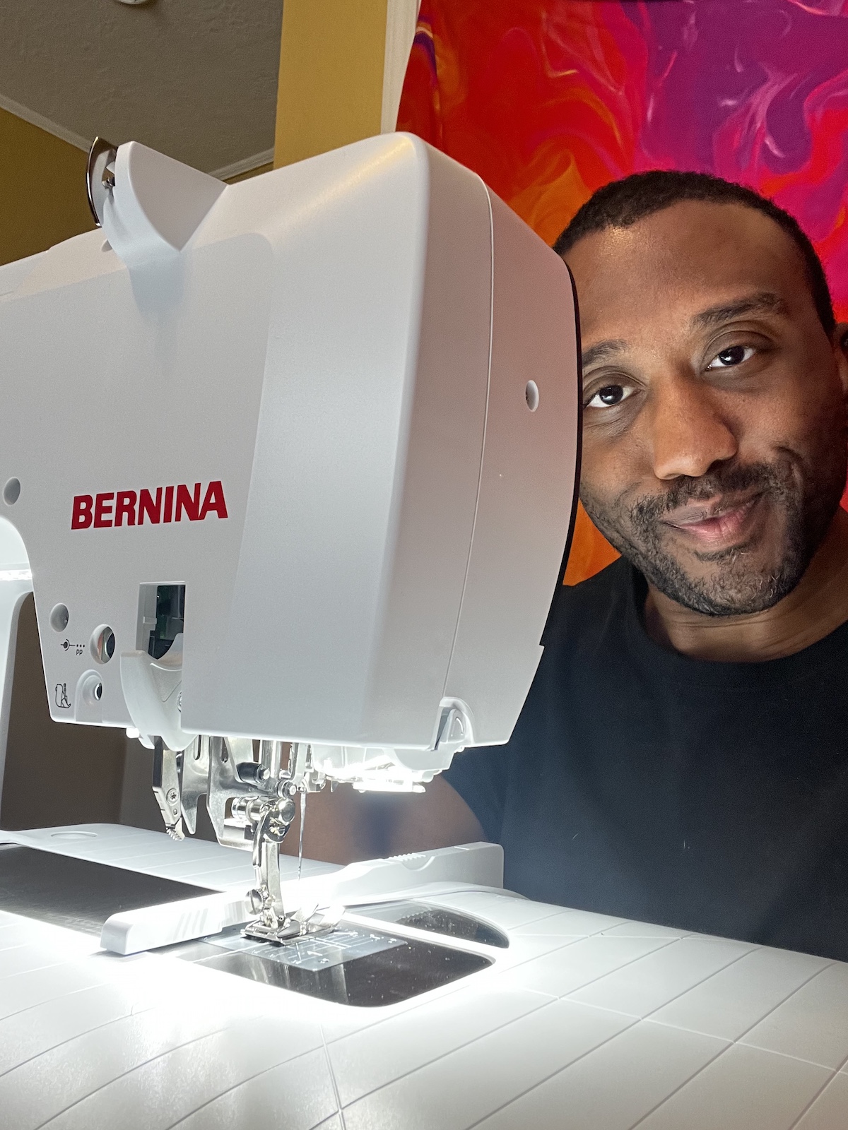 Black man sitting behind a BERNINA B 790 PRO sewing machine