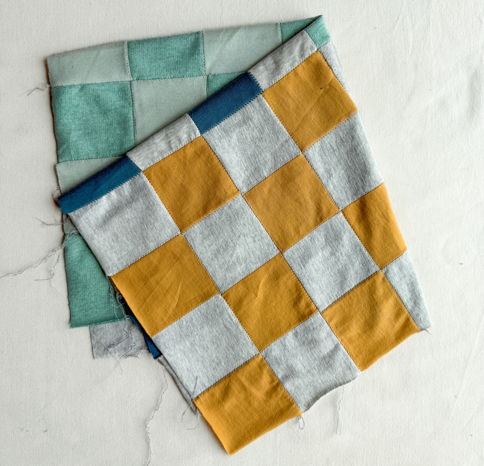 brightly colored t-shirts sewn into a checkerboard