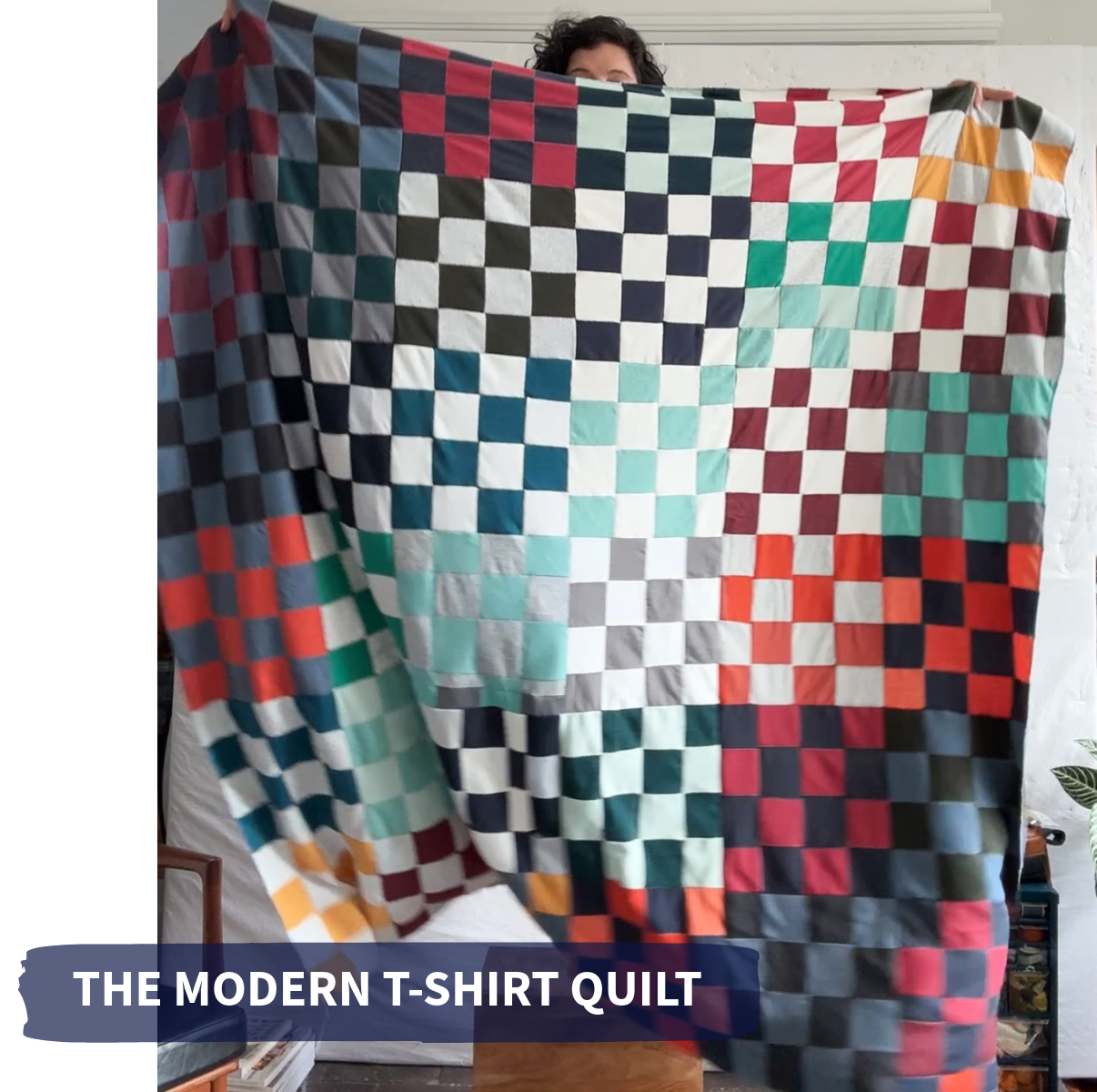 a checkerboard quilt in shades of red, blue, teal, white and orange