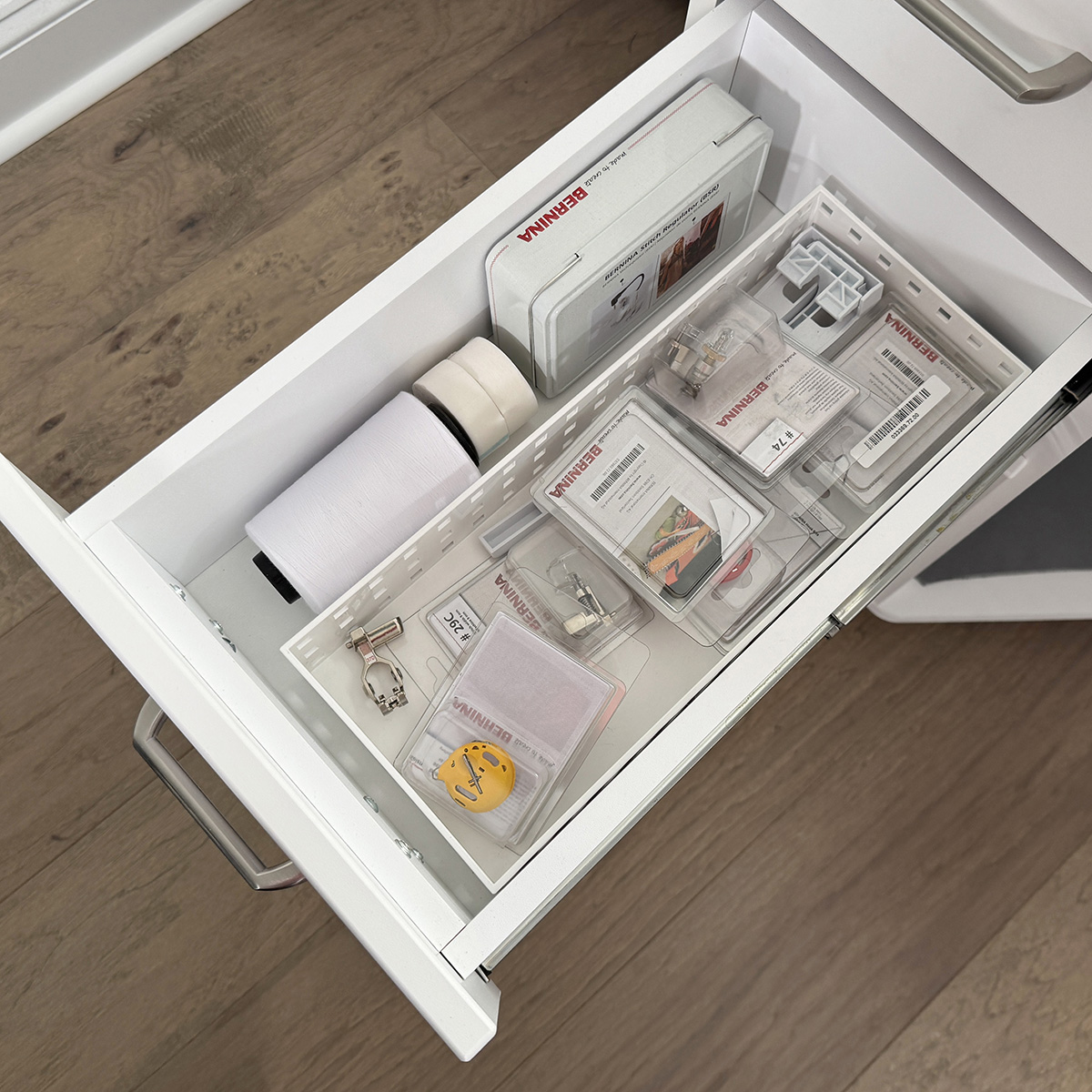 The second drawer holds mostly embroidery supplies. Things like OESD bobbin thread and tear-away tape, the high tension bobbin case, plus some extra feet that don't fit in my Barbie box, which I keep on top of the cabinet.