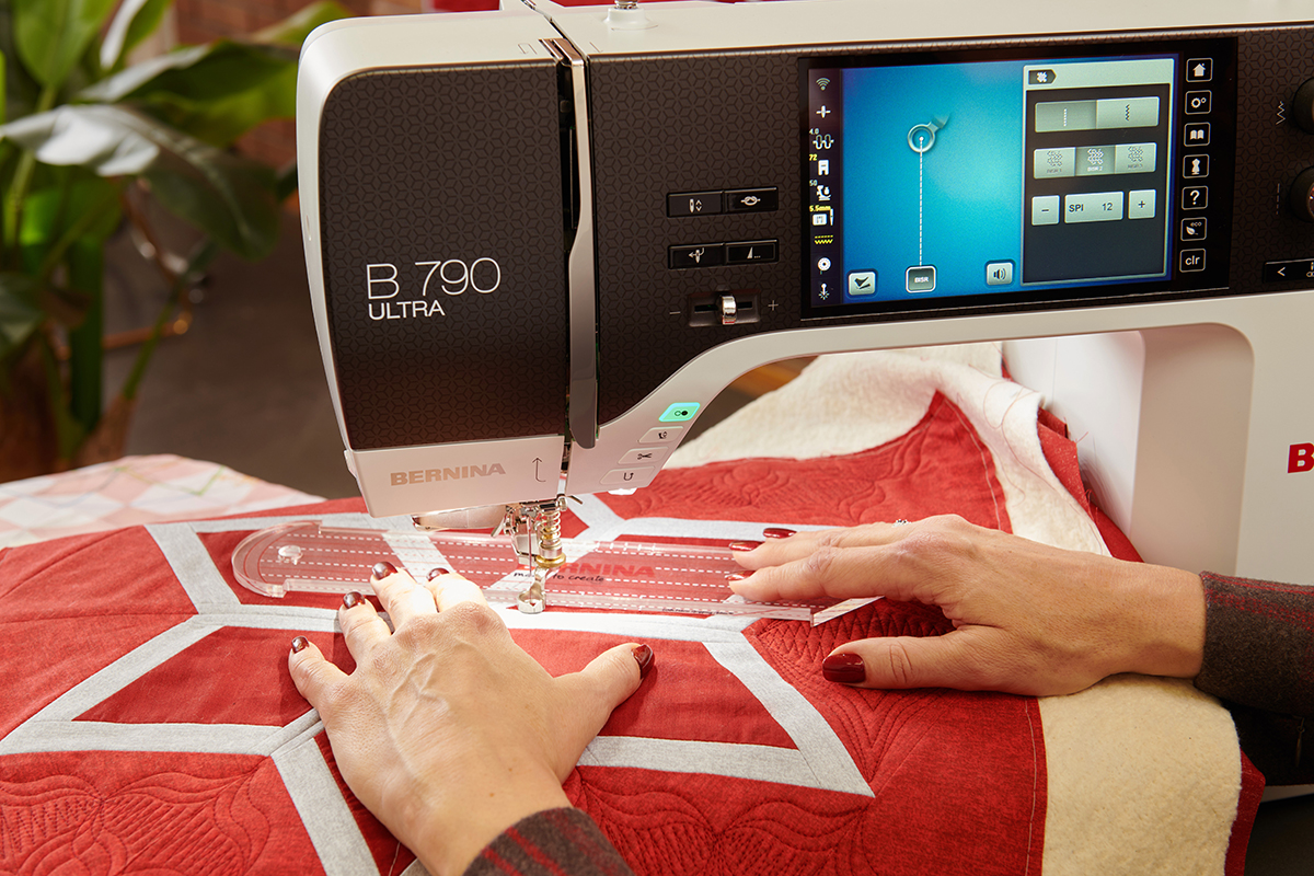 A person free-motion quilting with a straight line ruler on a sewing machine.