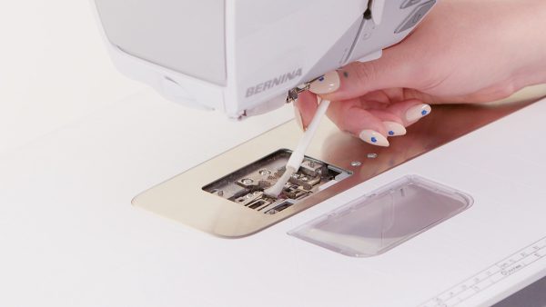 Use a brush to clean under the stitch plate